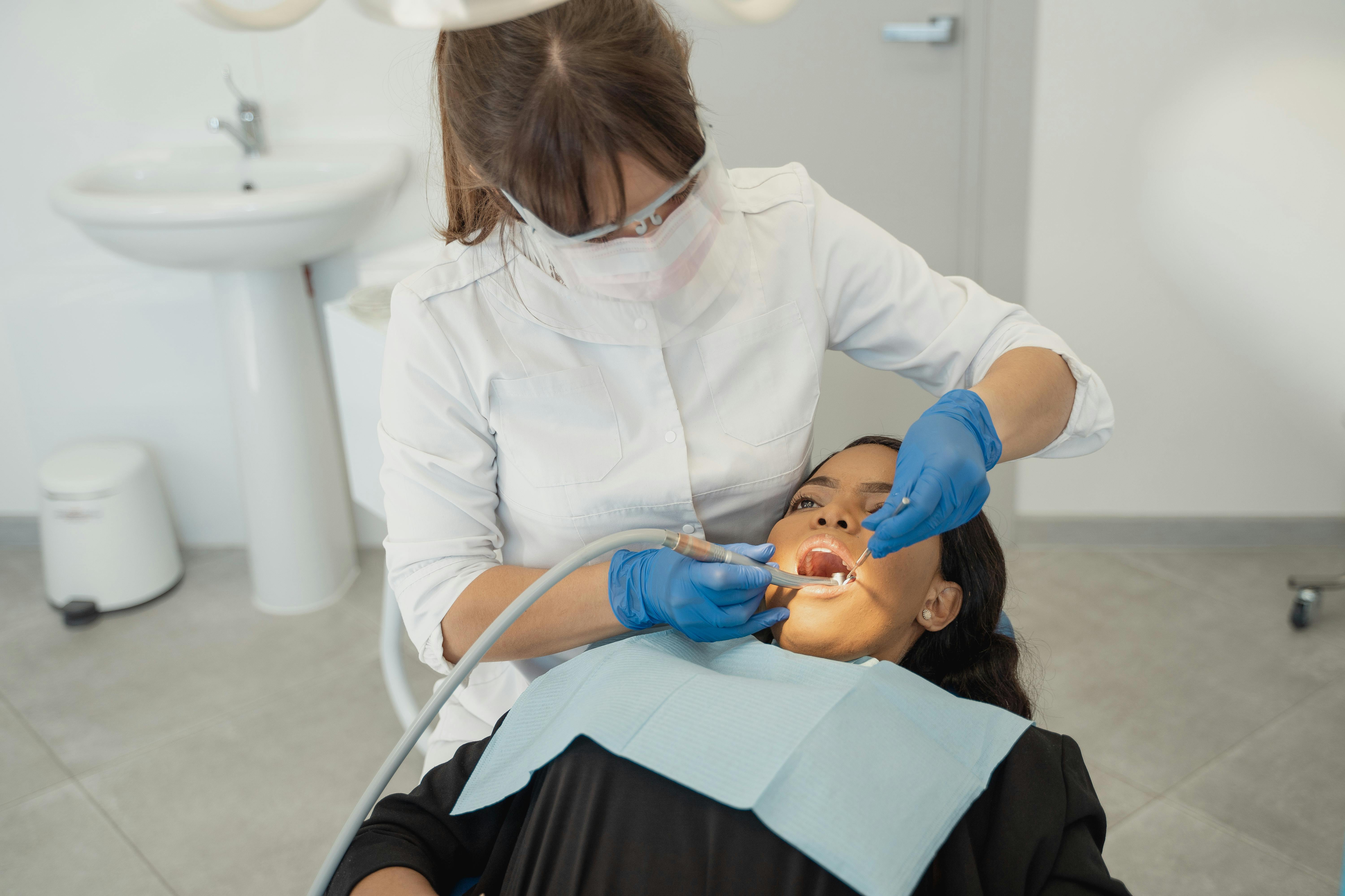 Woman looking into a mirror examining her mouth
