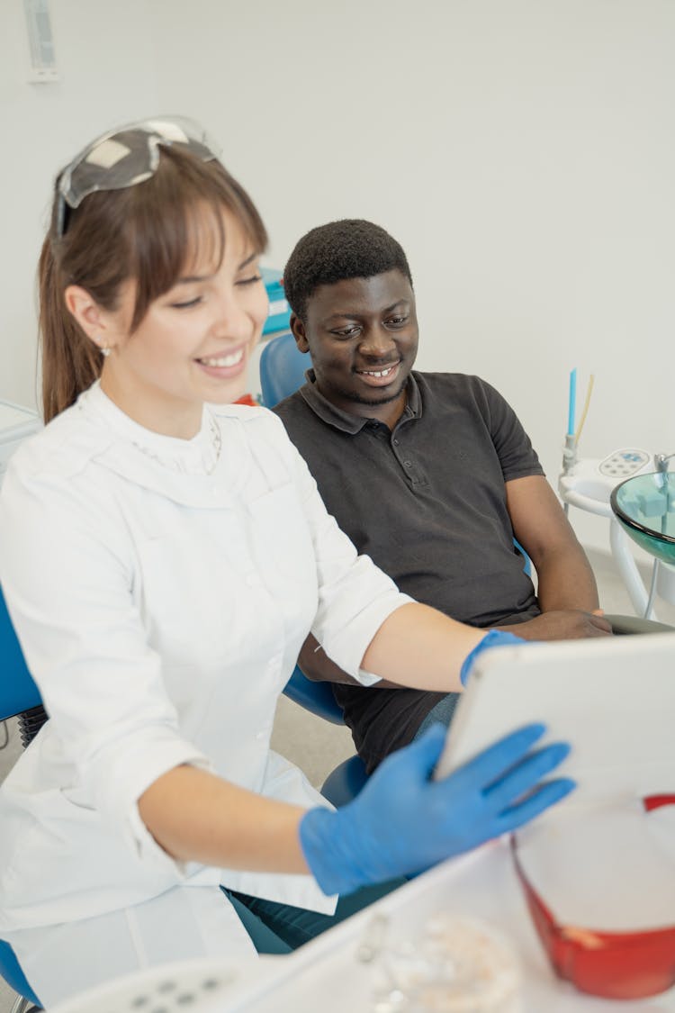 Female Dentist And Patient Looking At An Ipad 