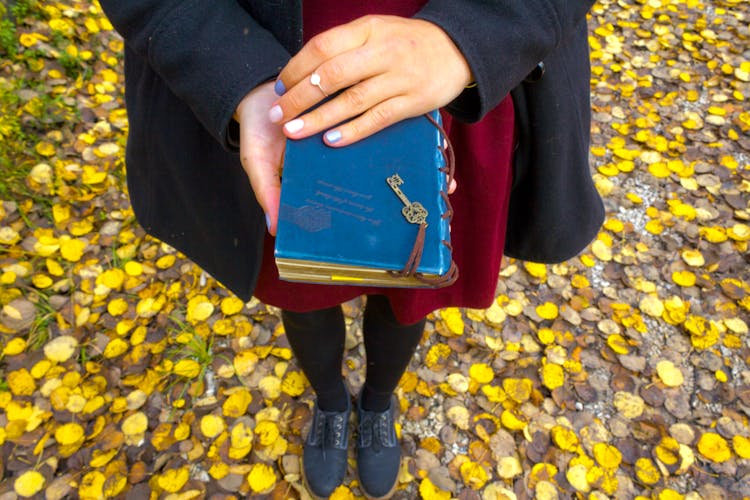 A Person Holding A Notebook With A Key