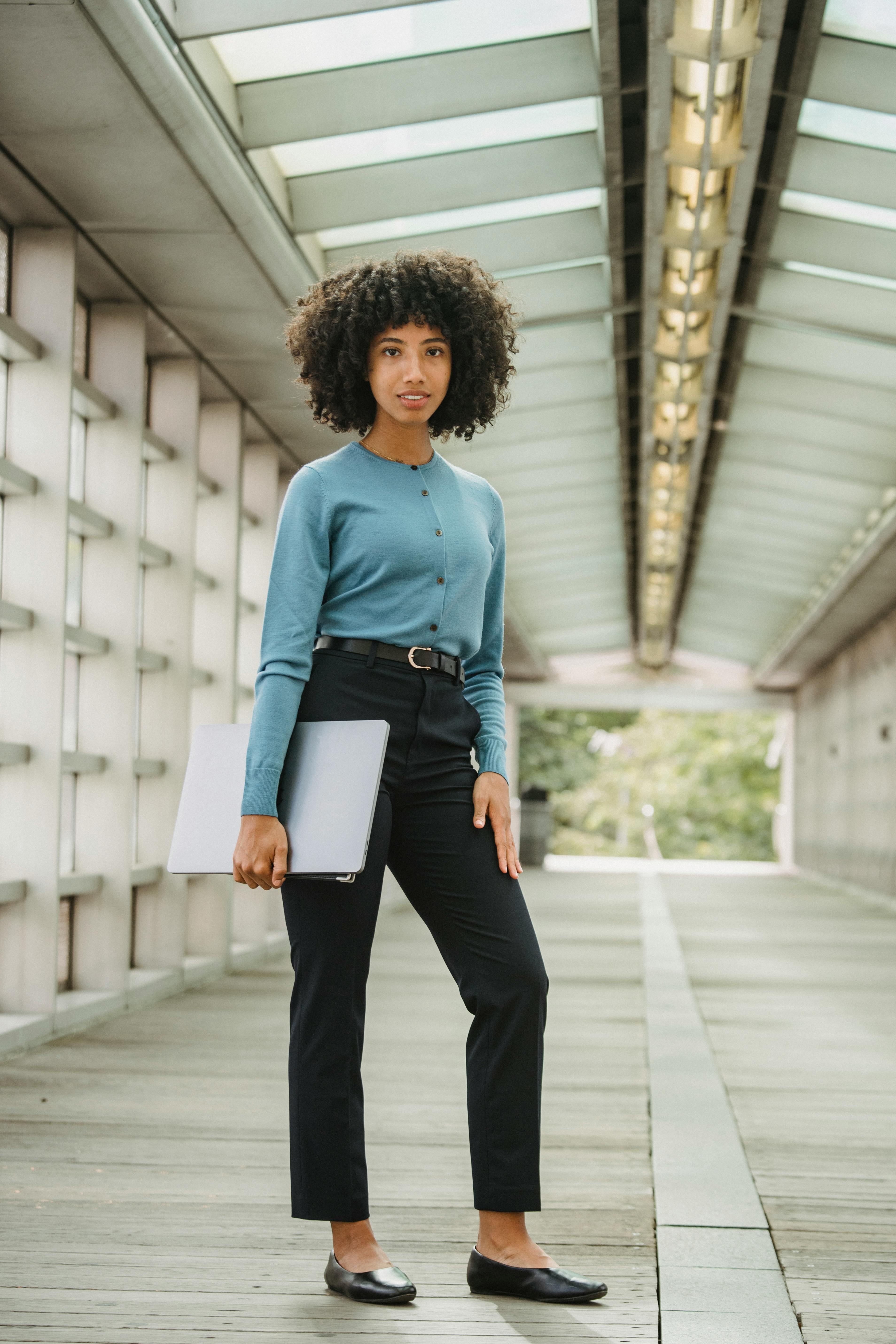 cheerful black woman with laptop in tunnel