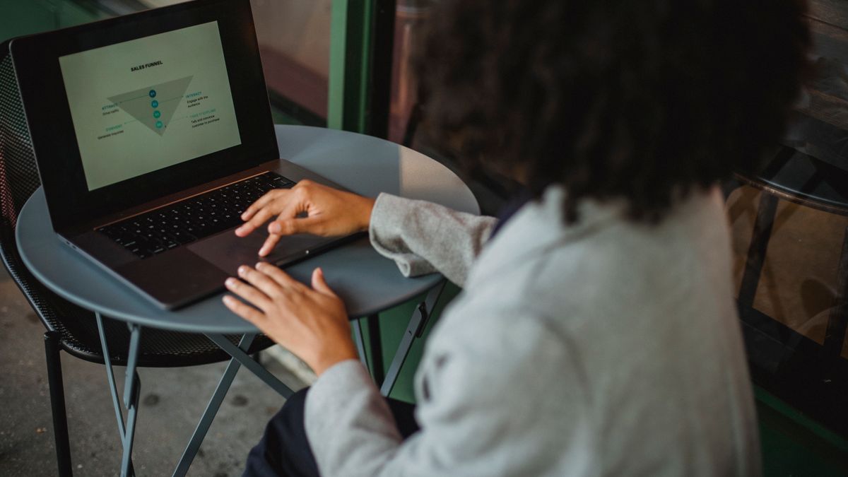 Traveler comparing hotel booking options on a laptop in a cafe