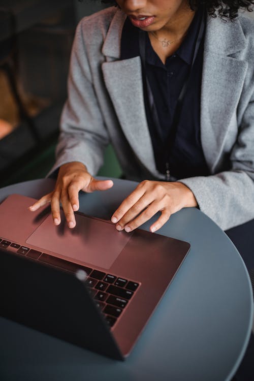 Free From above of crop anonymous ethnic remote employee surfing internet on netbook at table Stock Photo