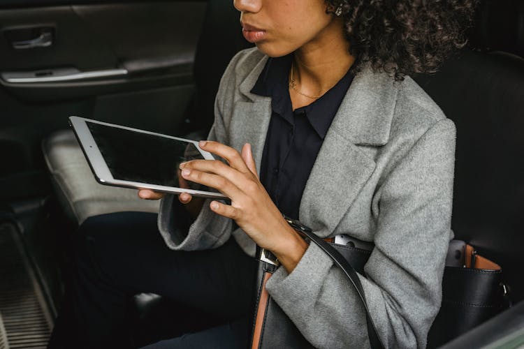 Crop Black Businesswoman With Tablet In Car