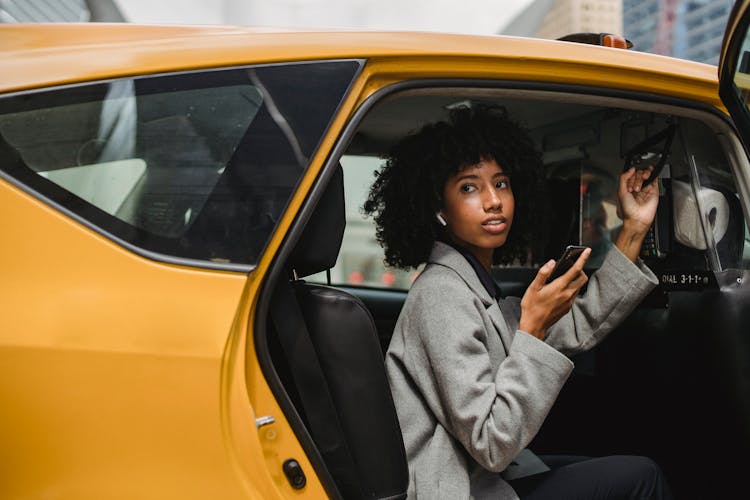 African American Woman Getting Out Of Yellow Cab