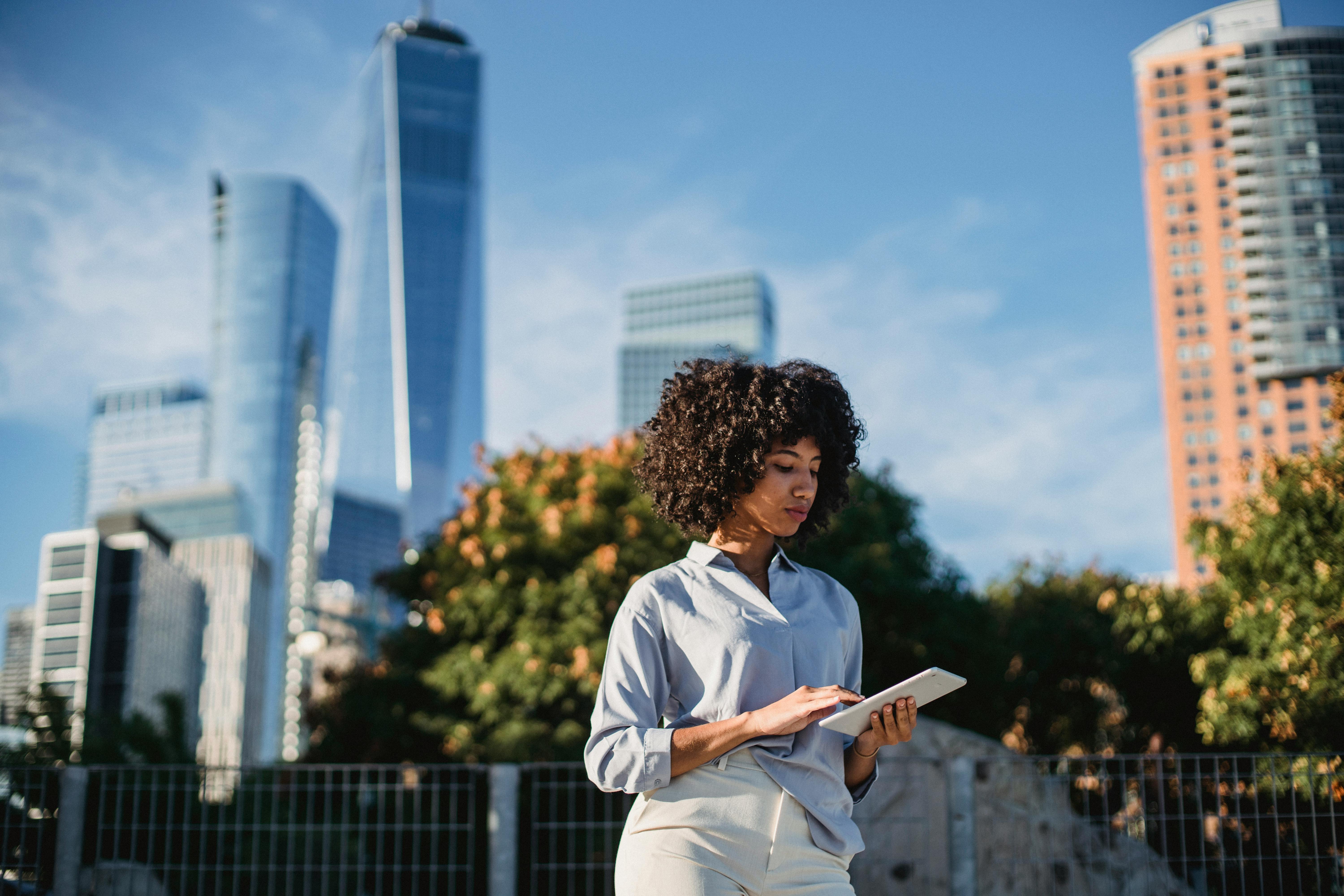 black woman browsing tablet in park