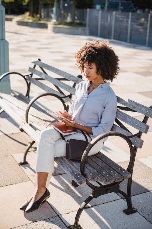 Woman Sitting on the Bench and Using Smart Phone 