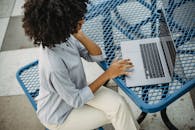 Photo of a Woman with Curly Hair Using the Touchpad of Her Laptop