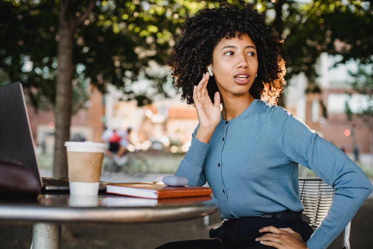 Photo Of A Woman Touching Her Earbud While Her Hand Is On Her Waist