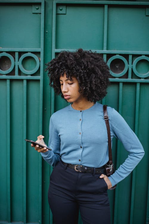 Female curly brunette hair wearing green bra top and hotpants, looking to  camera half smiling one hand on hip against purple Stock Photo - Alamy