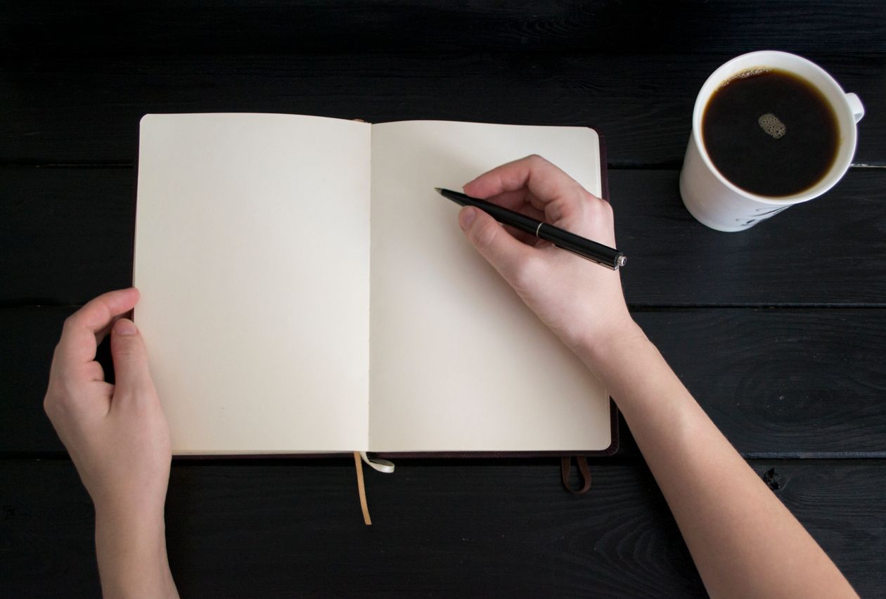 pen and journal on a wooden table for morning reflection