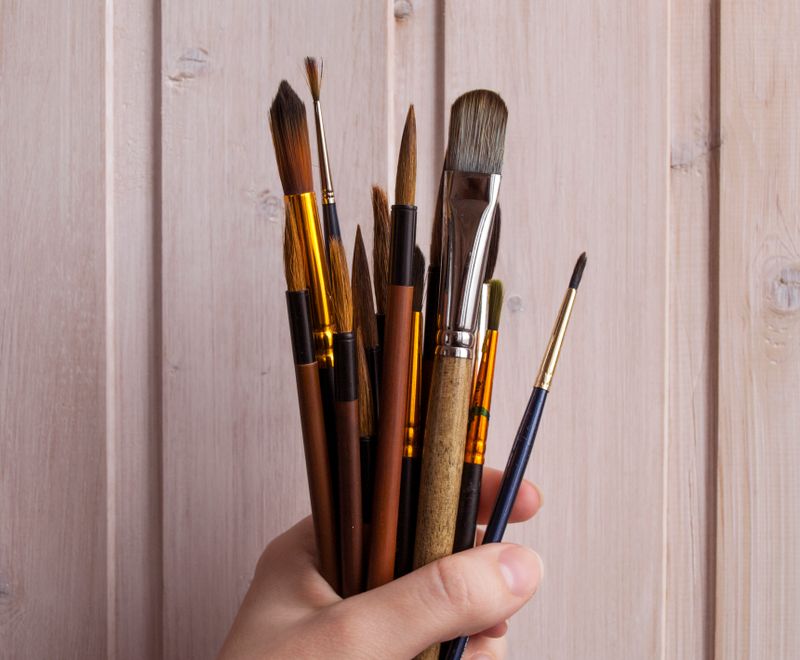 Wide flat brushes held in a hand