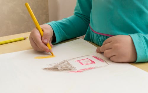 Free Photograph of a Child's Hands Using a Colored Pencil Stock Photo