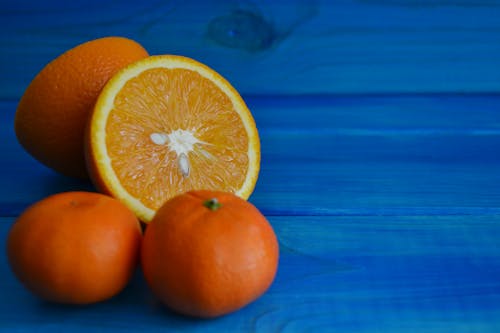 Close-Up Photograph of Oranges on a Blue Surface