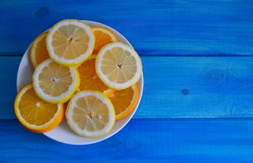 Free Slices of Lemon and Orange on a White Plate Stock Photo