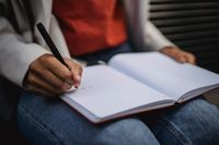 Hand writing in an open notebook — photo by Roberto Hund on Pexels