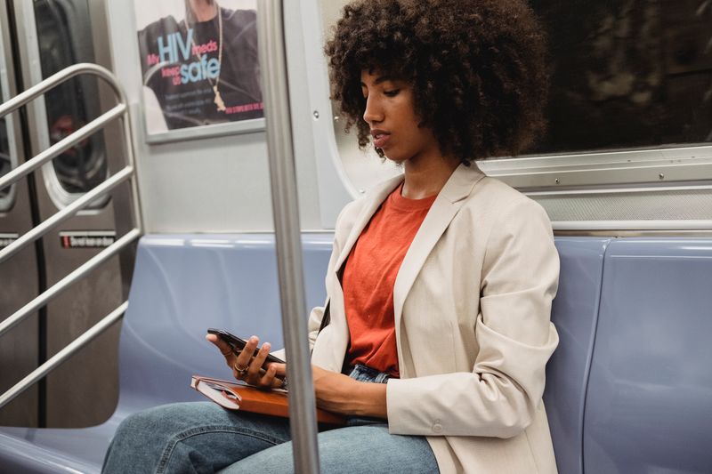 Woman traveling on a subway using her smartphone