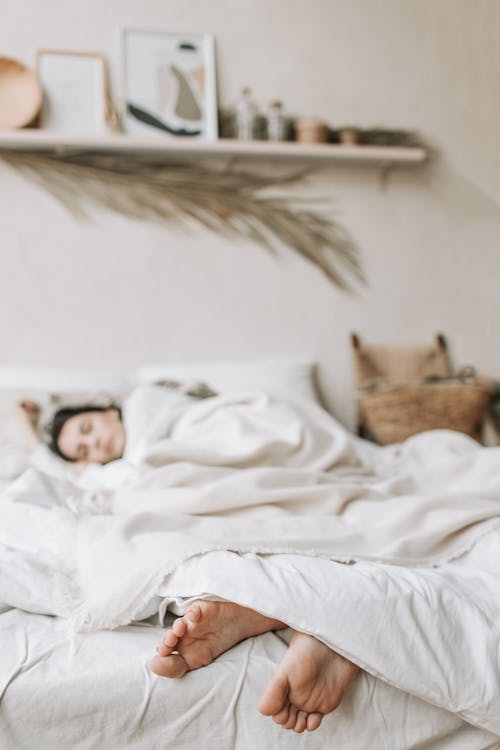 Free Photo of a Woman Sleeping on a Bed with a White Blanket Stock Photo