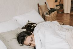 A peaceful woman sleeping comfortably in a cozy, minimalistic bedroom.