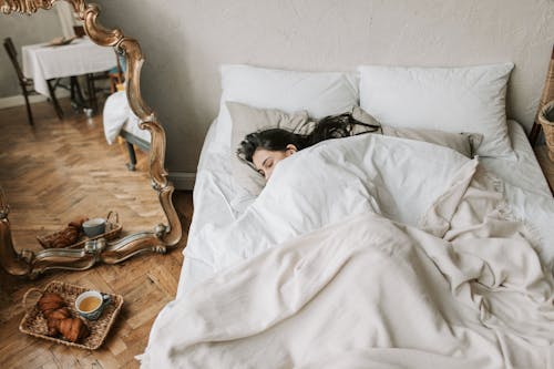 Boy Lying on Bed Covered With White Blanket