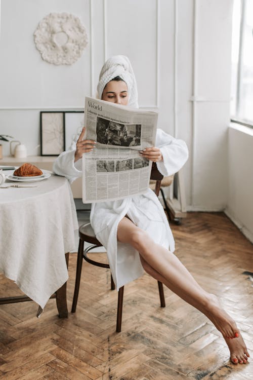 A Woman Reading A Newspaper in Her Bathrobe