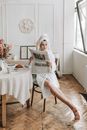 Woman in White Hijab Reading Newspaper