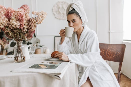 A woman enjoying breakfast with coffee and a croissant in a cozy indoor setting.