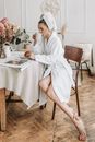 Woman in White Robe Sitting on Chair