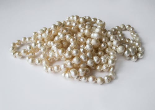 White Pearl Necklace on White Surface