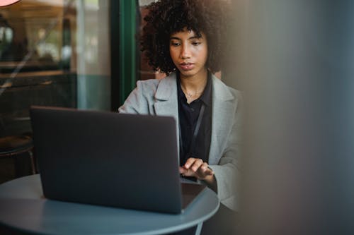 Woman in a Gray Blazer Working on Her Laptop