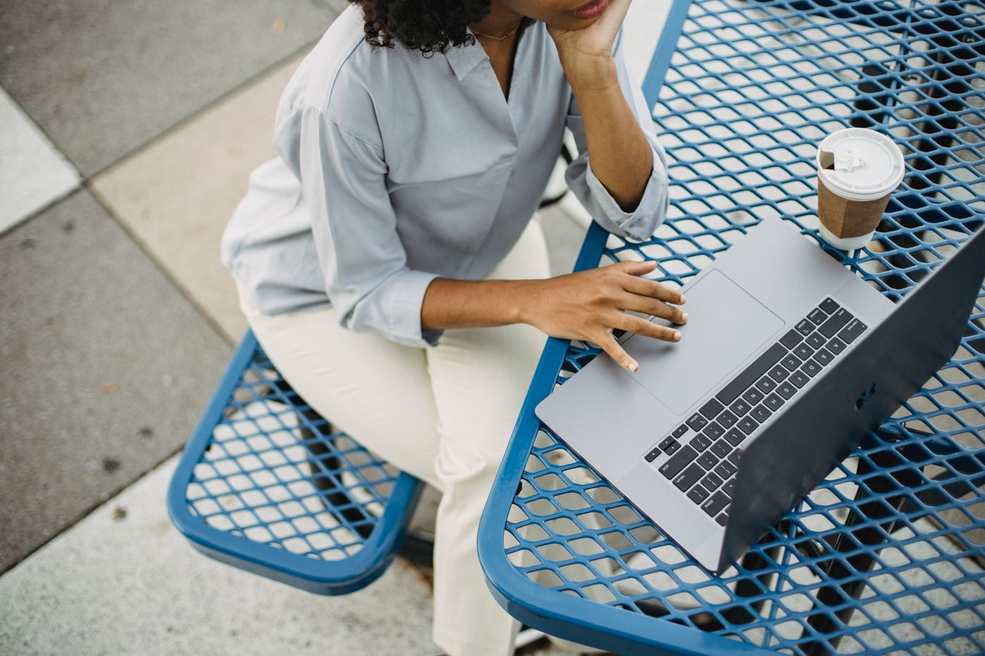 Black woman using a laptop and notebook to plan her finances