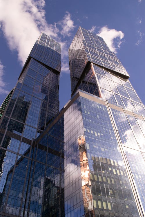 Glass Building with Twin Towers Under Blue Sky