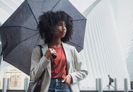 城市里，一个女人撑着伞站在雨中