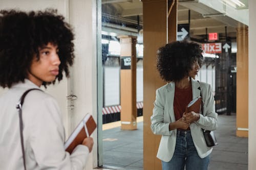 Free Photo of a Woman Holding a Notebook while Looking Away Stock Photo