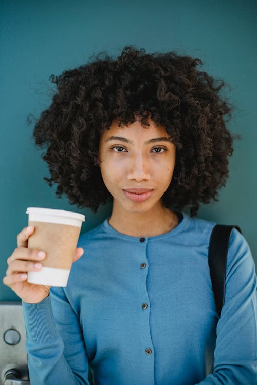 Portrait of a Woman with Curly Hair Holding a Cup of Coffee