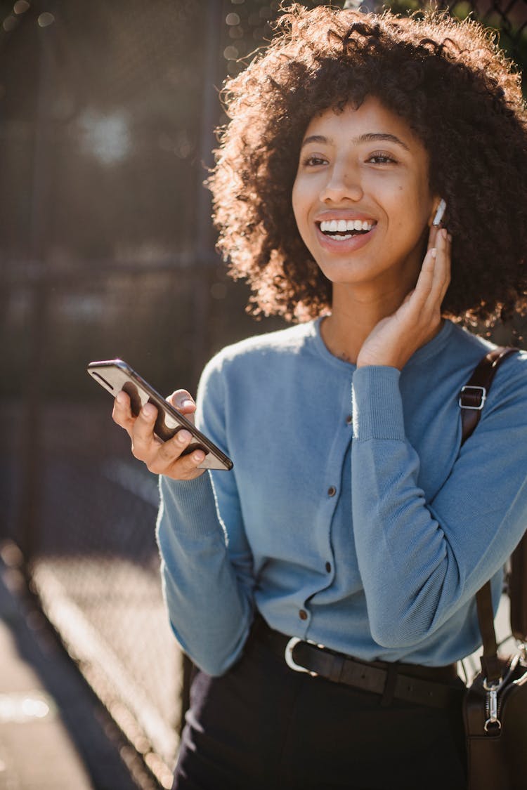 Woman In Blue Shirt Holding Smartphone