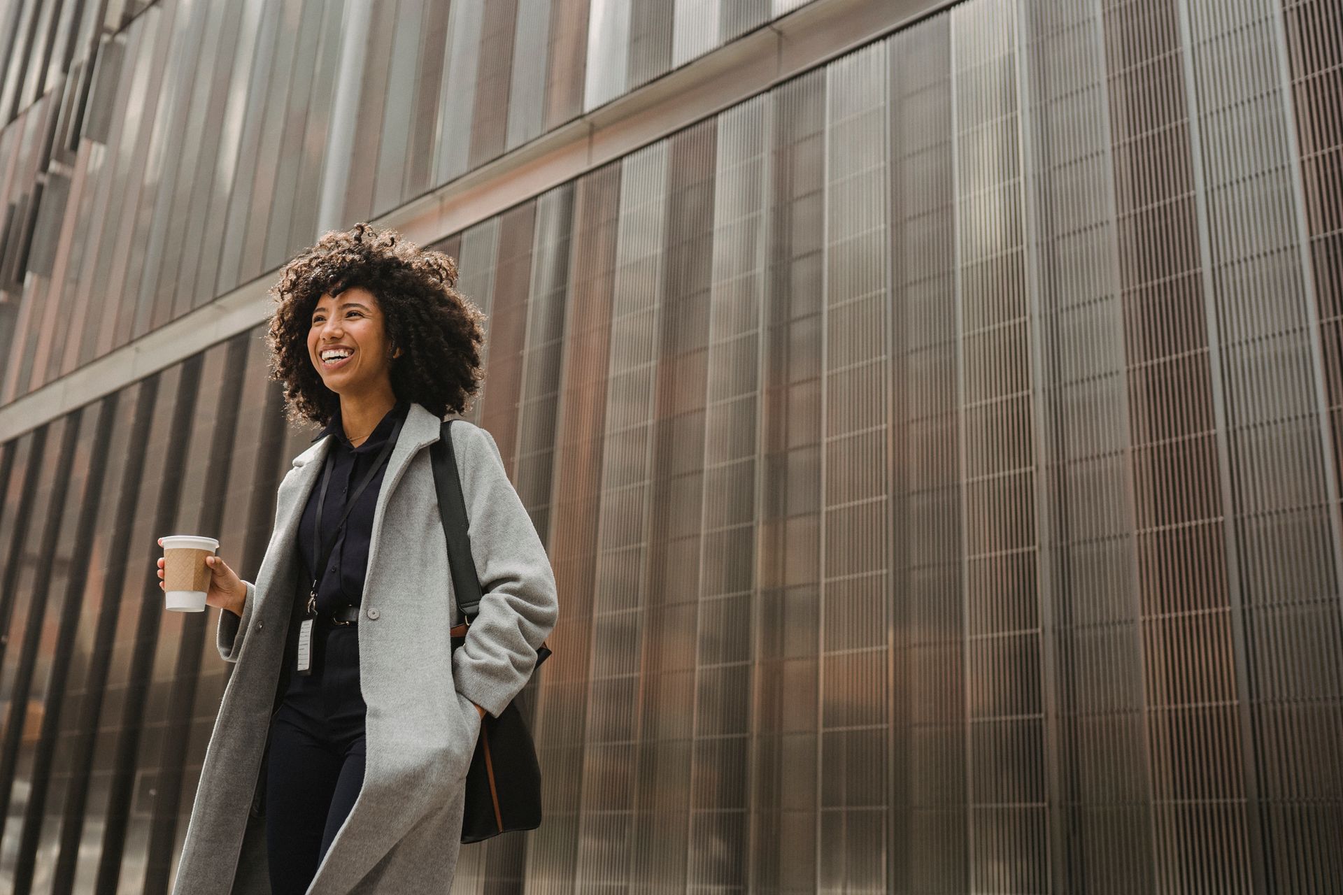 Woman in Gray Coat Standing Near Gray Steel Bars