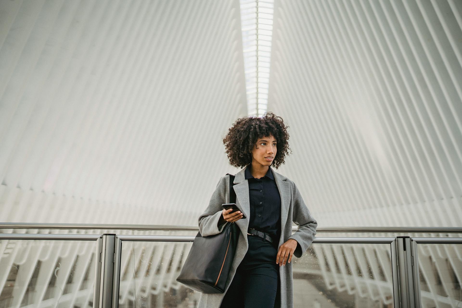 Woman in Gray Coat leaning on Stainless Steel Railing