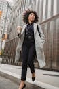 Woman in Gray Coat Stepping Down from Pavement