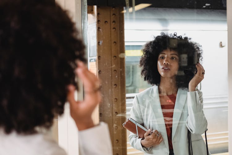 Woman In White Blazer In Front Of Mirror