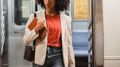Free Photo of a Woman in a White Blazer Holding a Brown Notebook Stock Photo