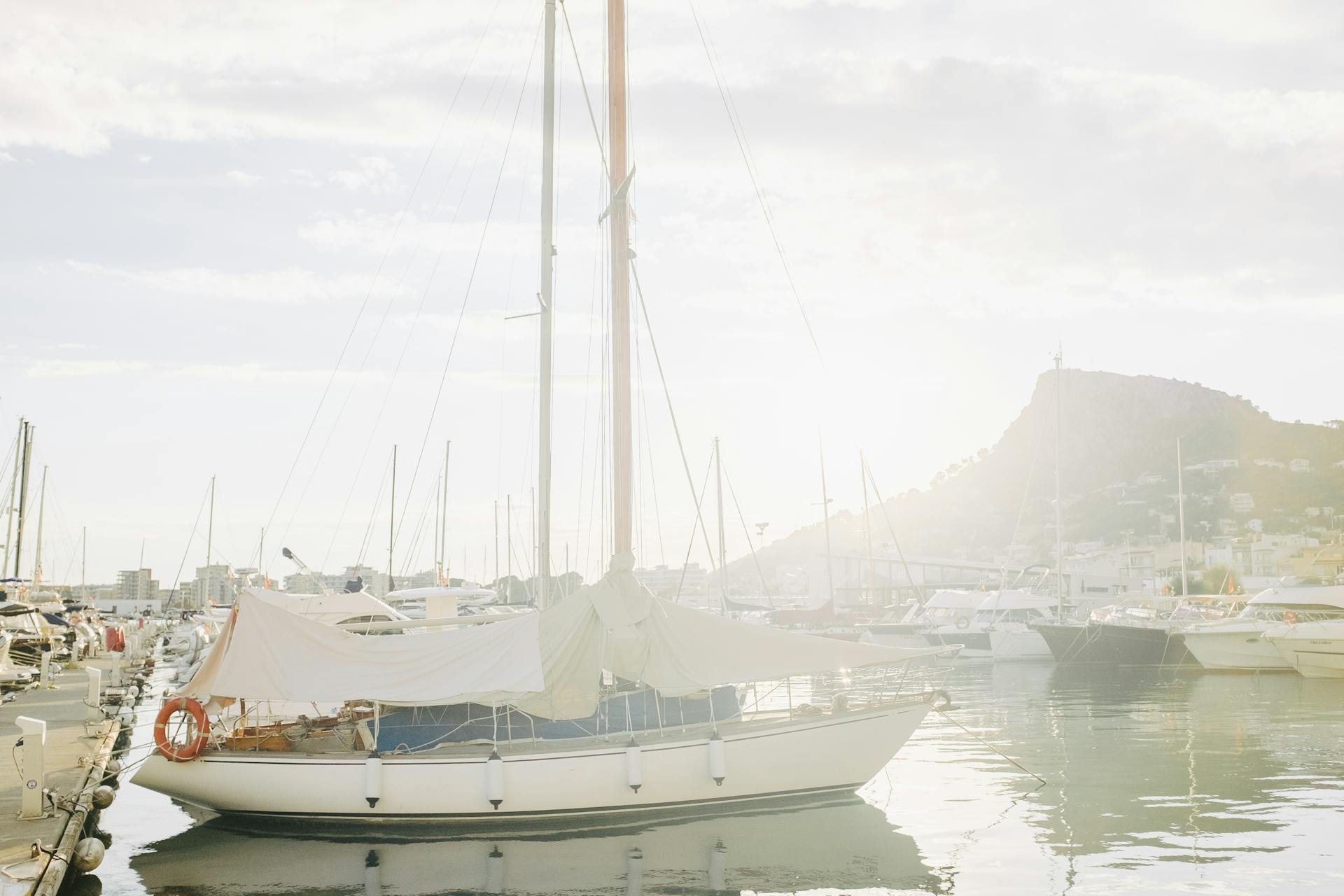 A serene marina scene with sailboats docked under bright sunlight, perfect for travel inspiration.