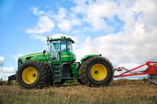 Free Photo of a Green and Yellow Tractor on a Farm Stock Photo