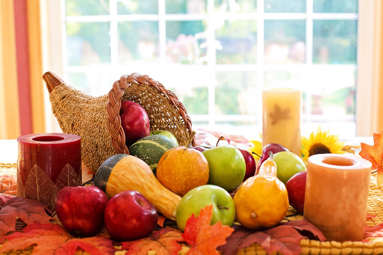 colorful cornucopia with fruits and candles celebrating the fall harve