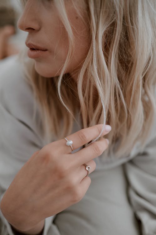 Photo of a Woman with Rings Touching Her Hair