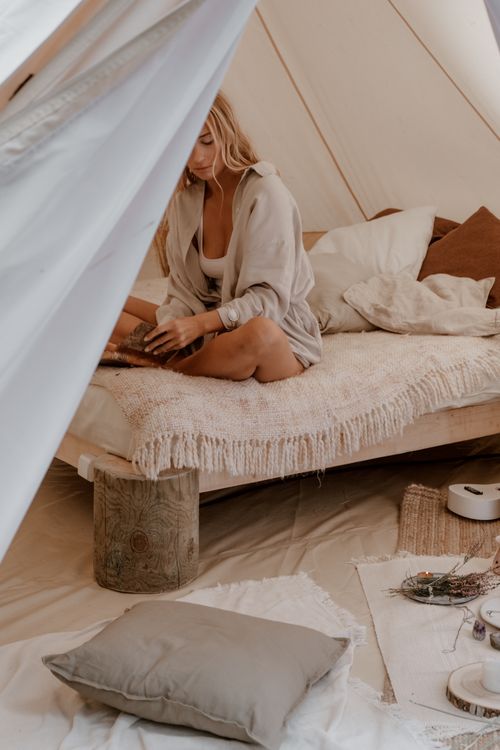 Free Woman enjoying a cozy indoor camping setup with pillows and blankets. Stock Photo