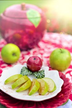 Fresh green apple slices arranged on a decorative plate with vibrant sunlight.
