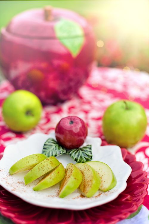 Free Fresh green apple slices arranged on a decorative plate with vibrant sunlight. Stock Photo
