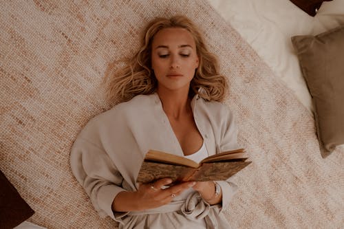 Free Overhead Shot of a Woman with Blond Hair Reading a Book Stock Photo