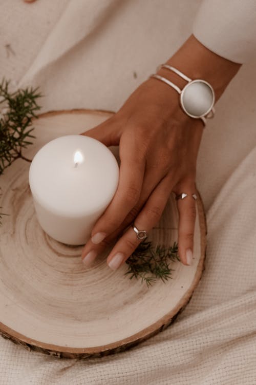 Photograph of a Person's Hand Holding a White Candle
