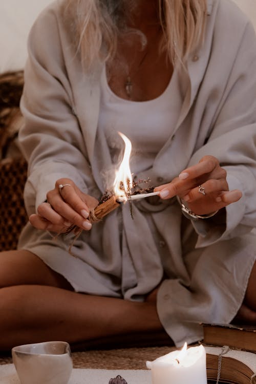 Woman in White Long Sleeve Shirt Holding Lighted Cigarette Stick